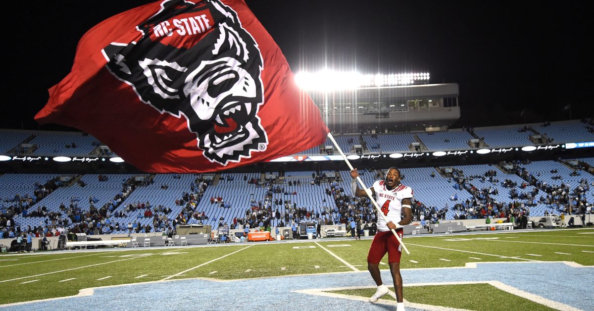 Nov 25, 2022; Chapel Hill, North Carolina, USA; North Carolina State Wolfpack safety Cyrus Fagan (4) waves the Wolfpack flag at midfield after the game at Kenan Memorial Stadium. Mandatory Credit: Bob Donnan-USA TODAY Sports